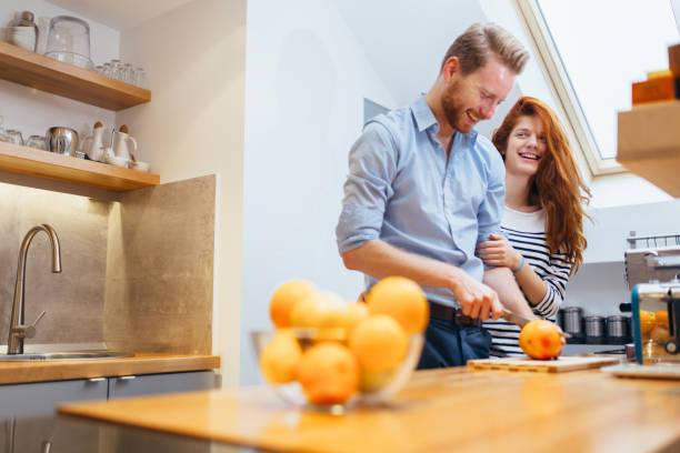 istock Couple making orange smoothie in kitchen from fresh oranges 654072152