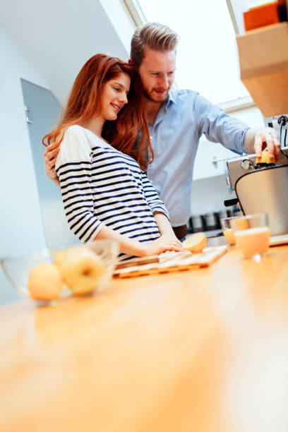 istock Husband and wife making orange juice in kitchen 654072514