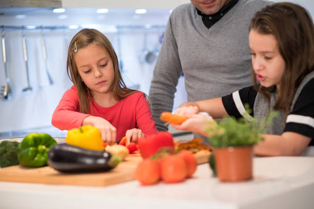 istock Little girls cutting vegetables 654073450