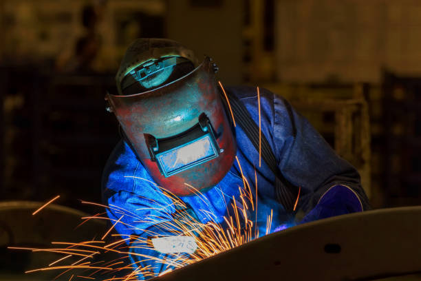 istock worker is welding metal part in car factory 654078968