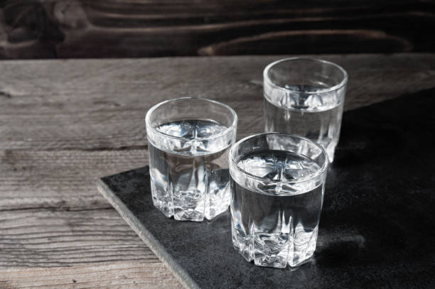 istock Vodka shots with ice cubes on black stone, 654079742