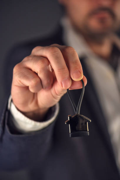 istock Real estate broker or agent offering house shaped key ring 654082996