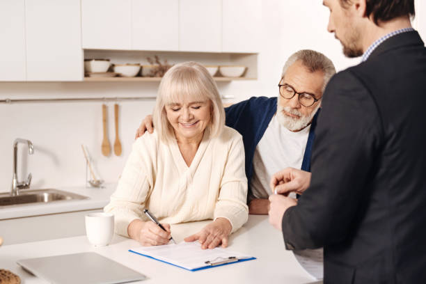 istock Attractive positive aged couple signing documents at home 654083196