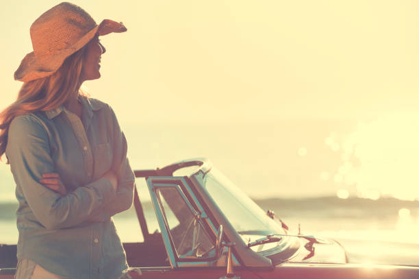 istock Woman relaxing beside a car. 654084748