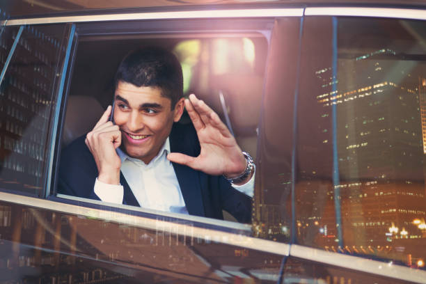 istock Businessman on a car using phone in big city 654089492