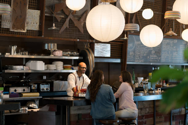 istock Waiter talking to customers at a cafe 654089710