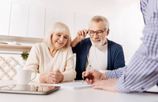 istock Creative agent showing house layout to aged couple of clients 654090634