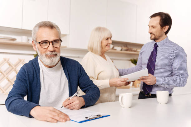 istock Bearded man signing agreement while his wife meeting notary 654091352