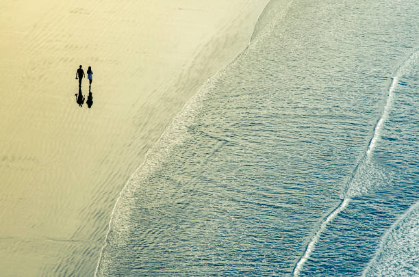 istock Couple walking alone by the sea 654091366