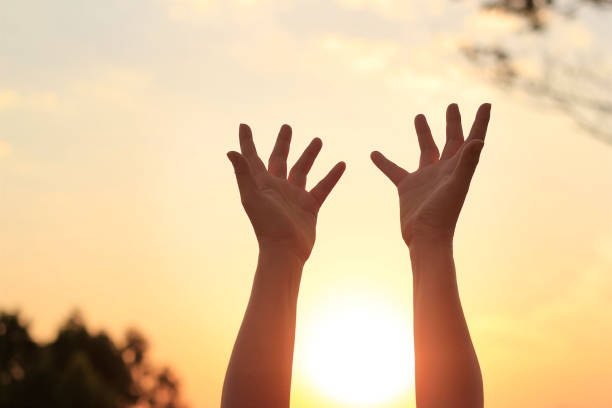 frau hände beten für segen gottes auf sonnenuntergang hintergrund - kneeling praying women begging stock-fotos und bilder