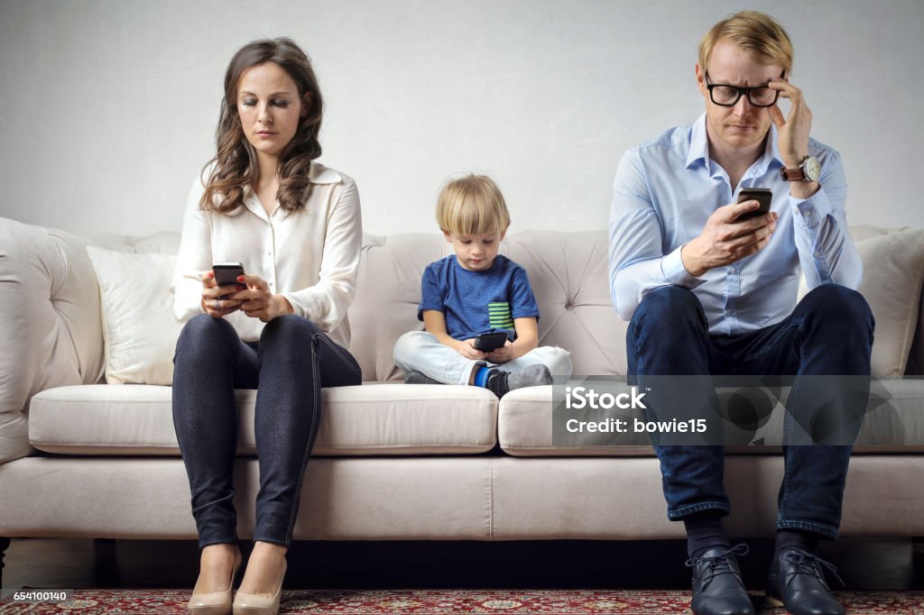 Family problems Young family is sitting on the couch and using mobile phones Addiction Stock Photo