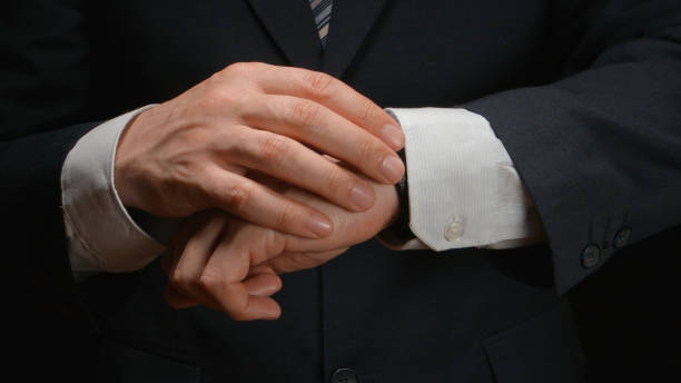 istock Businessman looks time on a wrist watch 654100228