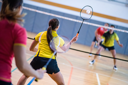 Male and female players in badminton mixed doubles match.
