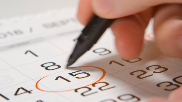 istock Signing a day on a calendar by red pen 654111520