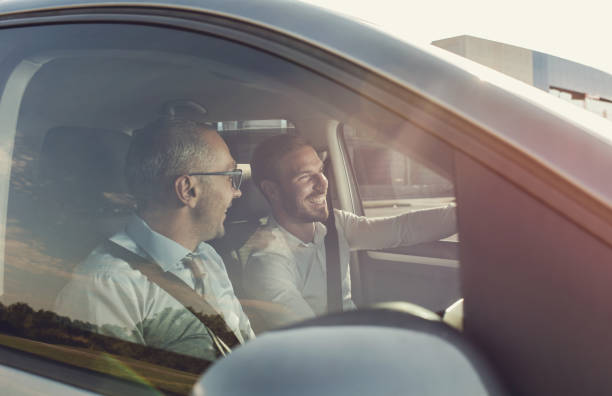 Happy business colleagues going on a trip by car.