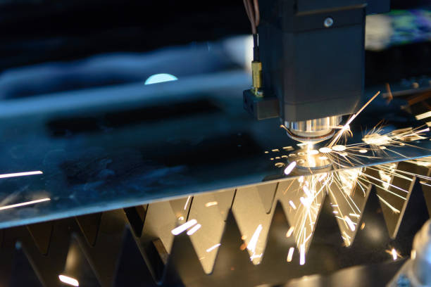 The CNC laser cut machine The CNC laser cut machine while cutting the sheet metal with the sparking light.The hi-precision sheet cutting process by laser cut laser cutting metal stock pictures, royalty-free photos & images