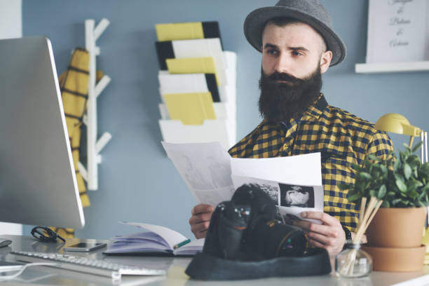 istock Pensive man selecting the best pictures 654123264