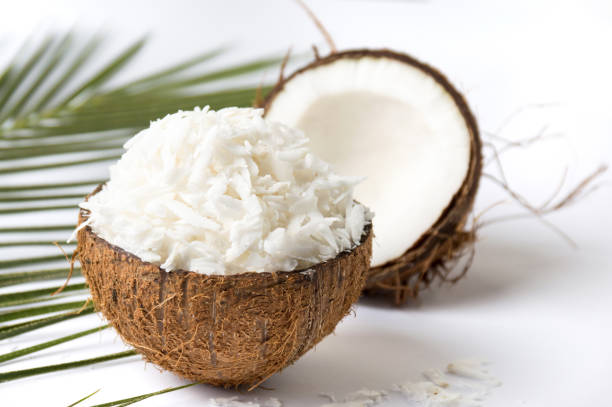 fruta de coco rallado en una concha - coconut flakes fotografías e imágenes de stock