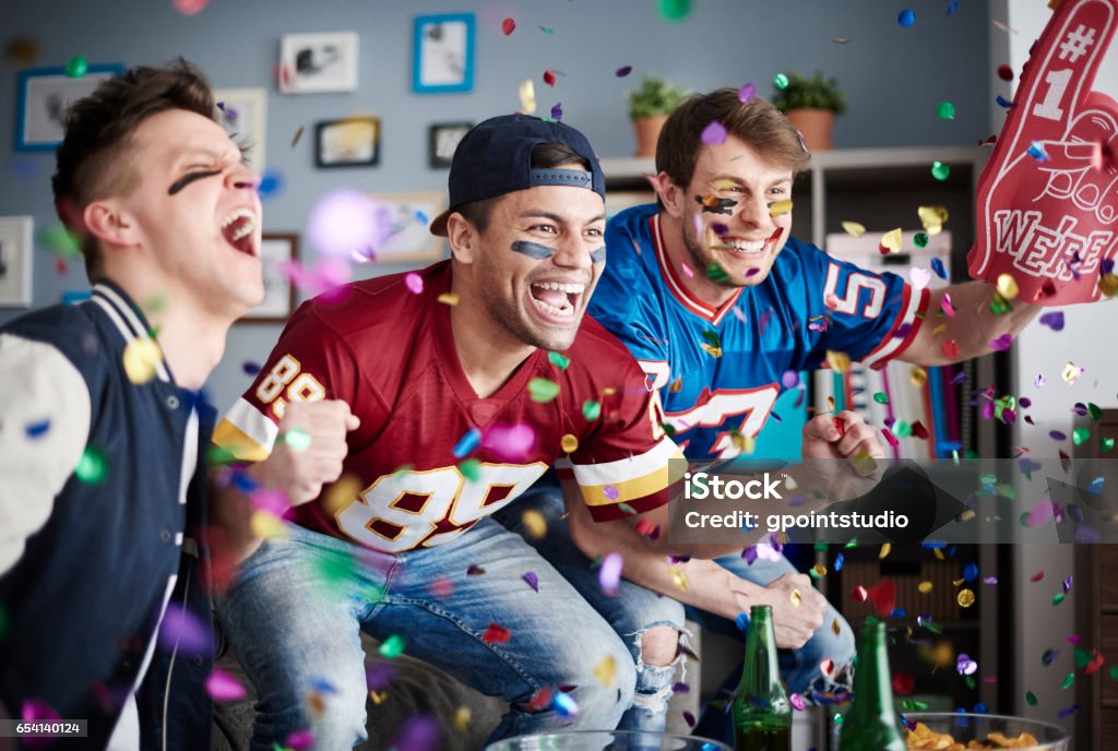 American football fans among falling confetti American Football - Sport Stock Photo