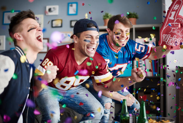 American football fans among falling confetti American football fans among falling confetti fan enthusiast photos stock pictures, royalty-free photos & images
