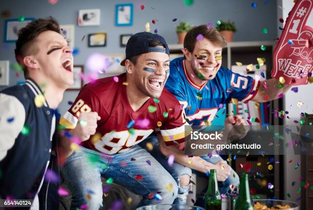 American Football Fans Among Falling Confetti Stock Photo - Download Image Now - American Football - Sport, Fan - Enthusiast, Party - Social Event