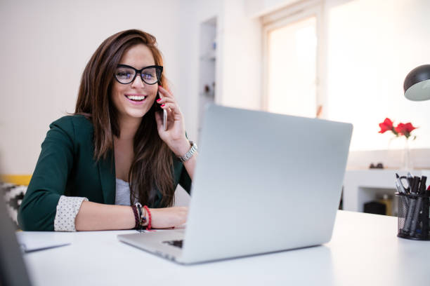 istock Happy woman working using multiple devices on a desk at home 654141170