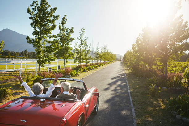 Our happiness is the only thing that matters now Shot of a senior couple going on a road trip convertible photos stock pictures, royalty-free photos & images
