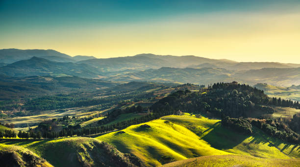 istock Volterra winter panorama, rolling hills green fields  sunset. Tuscany, Italy 654147836