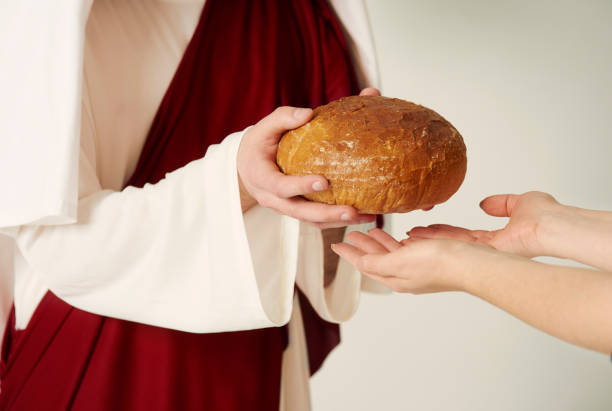 istock Christs hands handing over loaf of bread 654153688