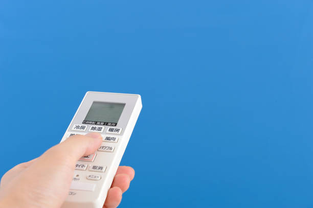 istock Hand of man to operate the air conditioning remote control 654157400