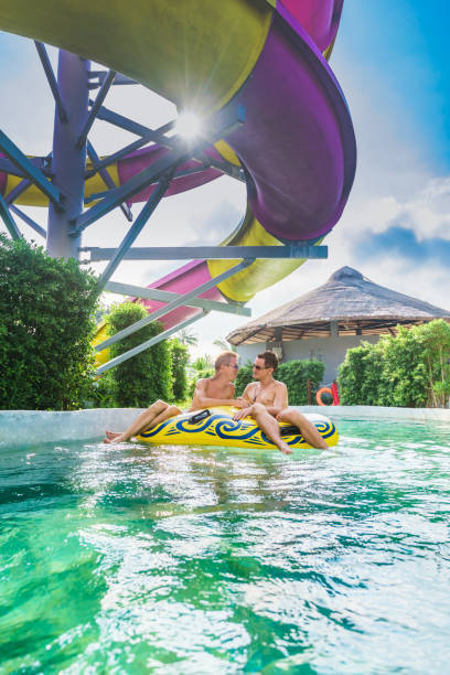 istock Homosexual couple having fun in waterpark 654160342