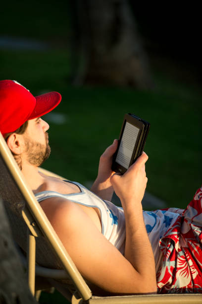 ビーチ、ハワイ、米国で電子書籍を読んでいる人 - reading beach e reader men ストックフォトと画像