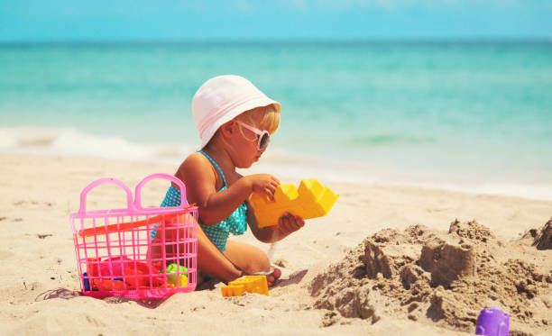 istock cute little girl play with sand on beach 654171532