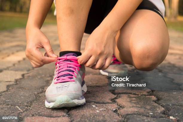 Zapatos De Runningmujer Atar Cordones De Zapatos Primer Plano Del Corredor De Fitness Deportivo Femenino Preparándose Para Correr Al Aire Libre En El Sendero Forestal A Finales Del Verano O Otoño Imágenes De Estilo De Efecto Vintage Foto de stock y más banco de imágenes de Actividad móvil general