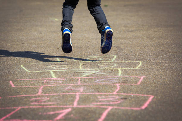 istock little boy playing hopscotch on playground 654174664