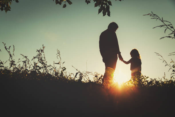 istock father with little daughter walk in sunset 654174716