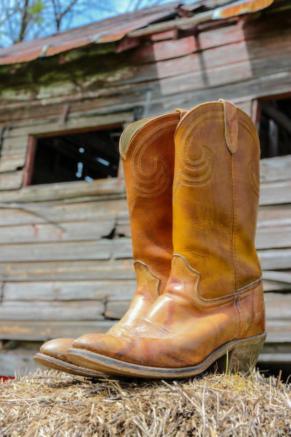 istock Old cowboy boots on bale of hay 654180910