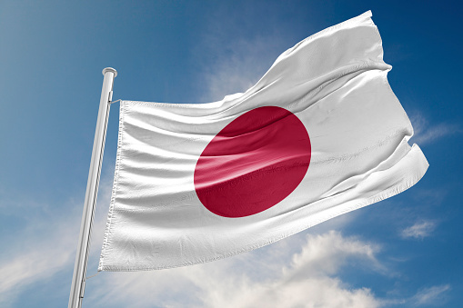 Japanese flag is waving at a beautiful and peaceful sky in day time while sun is shining. 3D Rendering