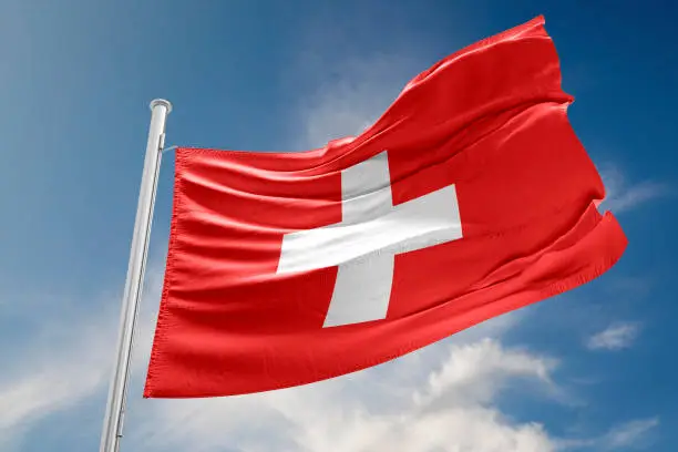 Swiss flag is waving at a beautiful and peaceful sky in day time while sun is shining. 3D Rendering