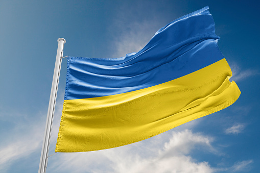 Bandera de Ucrania está agitando contra el cielo azul photo