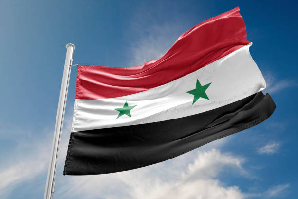 istock Syrian Flag is Waving Against Blue Sky 654181380