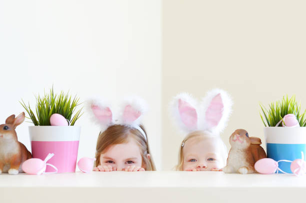 deux soeurs adorables portant des oreilles de lapin le jour de pâques - figurine easter egg easter holiday photos et images de collection