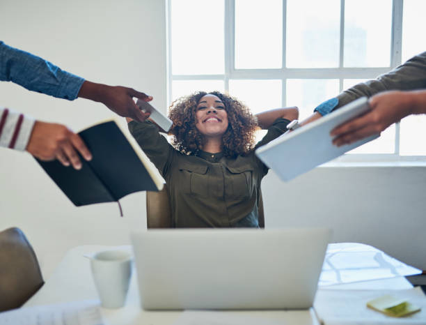 Breaking away from busyness Shot of a young woman taking a break during a demanding day at work delegating stock pictures, royalty-free photos & images