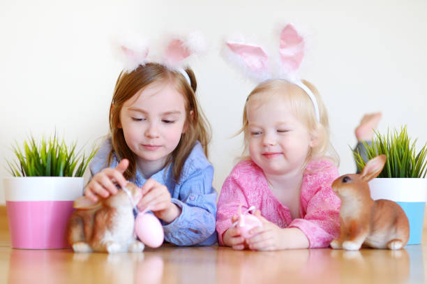 istock Two adorable little sisters wearing bunny ears on Easter 654189250