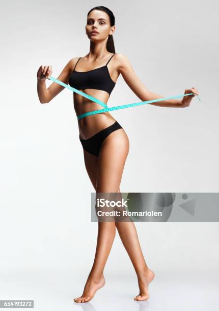 Thin Girl In Black Underwear With A Measuring Ribbon At The Waist Stock Photo - Download Image Now