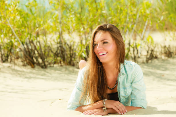 istock Young woman lying on grassy dune 654193670