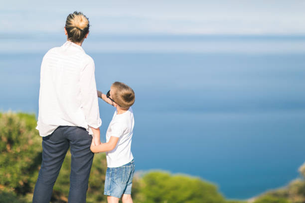 istock Single mother with two sons looking at sea 654200720