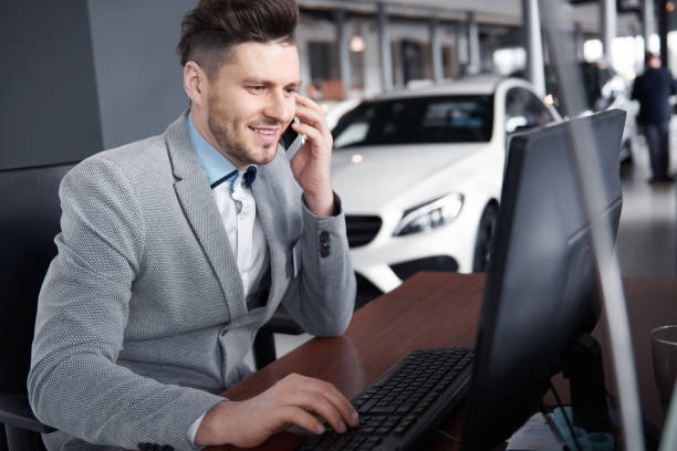 Car dealer on the phone talking with client Car dealer on the phone talking with client car salesperson photos stock pictures, royalty-free photos & images