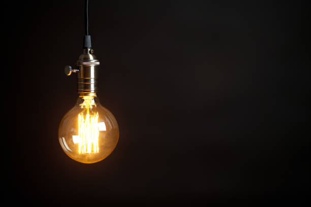 istock Vintage incandescent Edison type bulb on black background 654207078