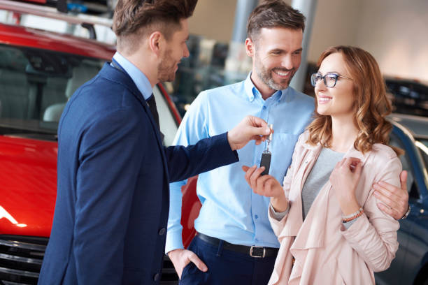 istock Happy couple getting keys from salesman 654213766